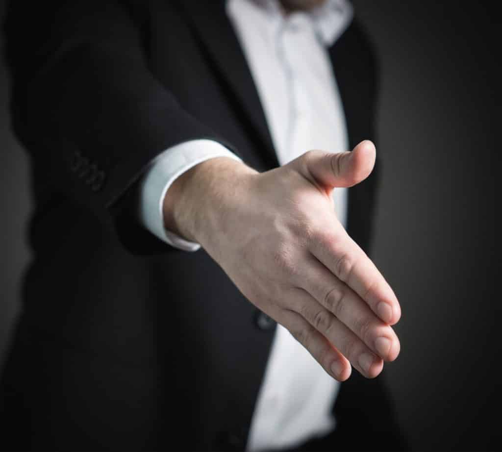professional in a suit extending a handshake